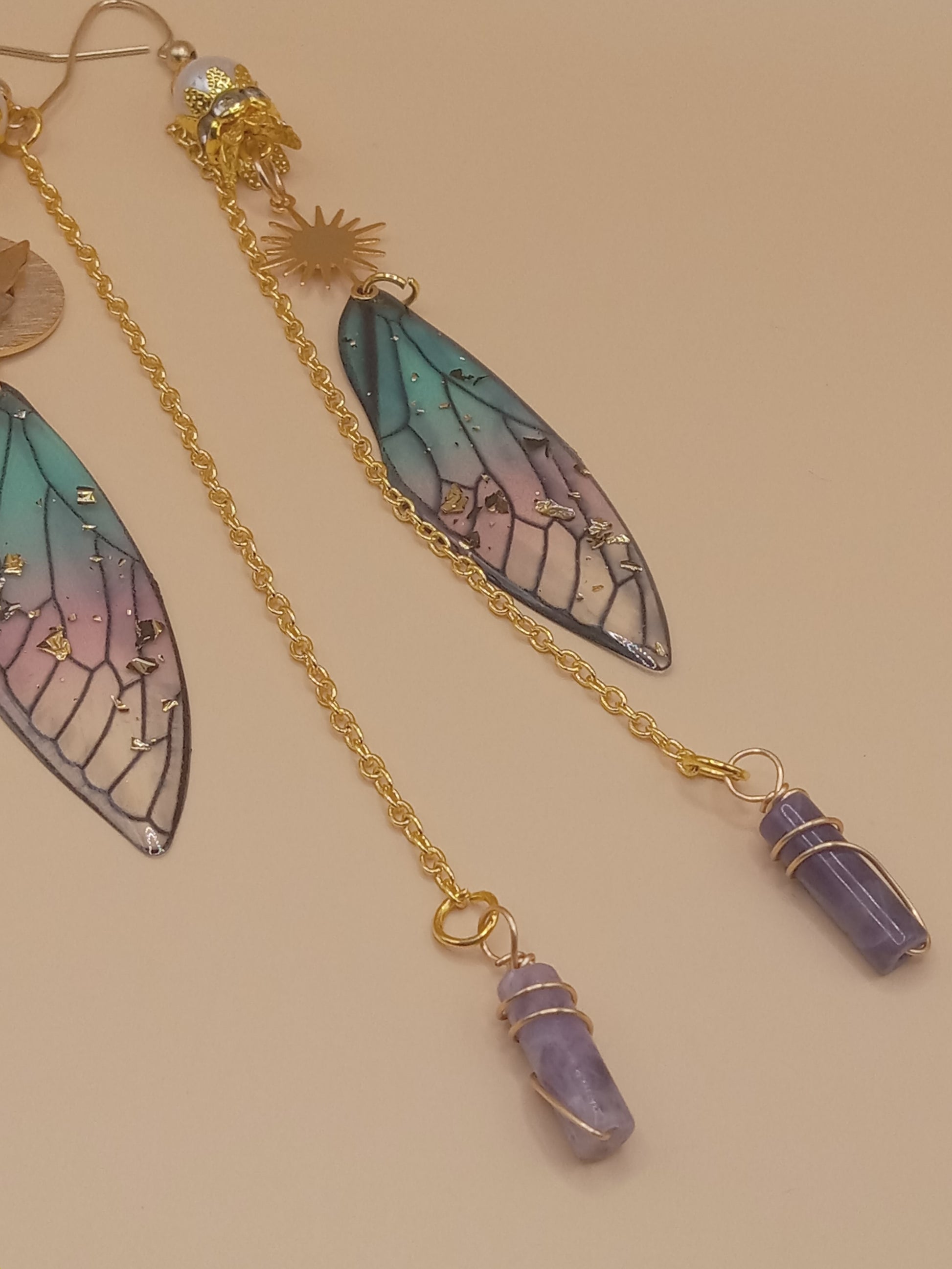 Sacred Moon Candle Co blue and violet fairy earrings with gold chain gradient wing charms and amethyst points