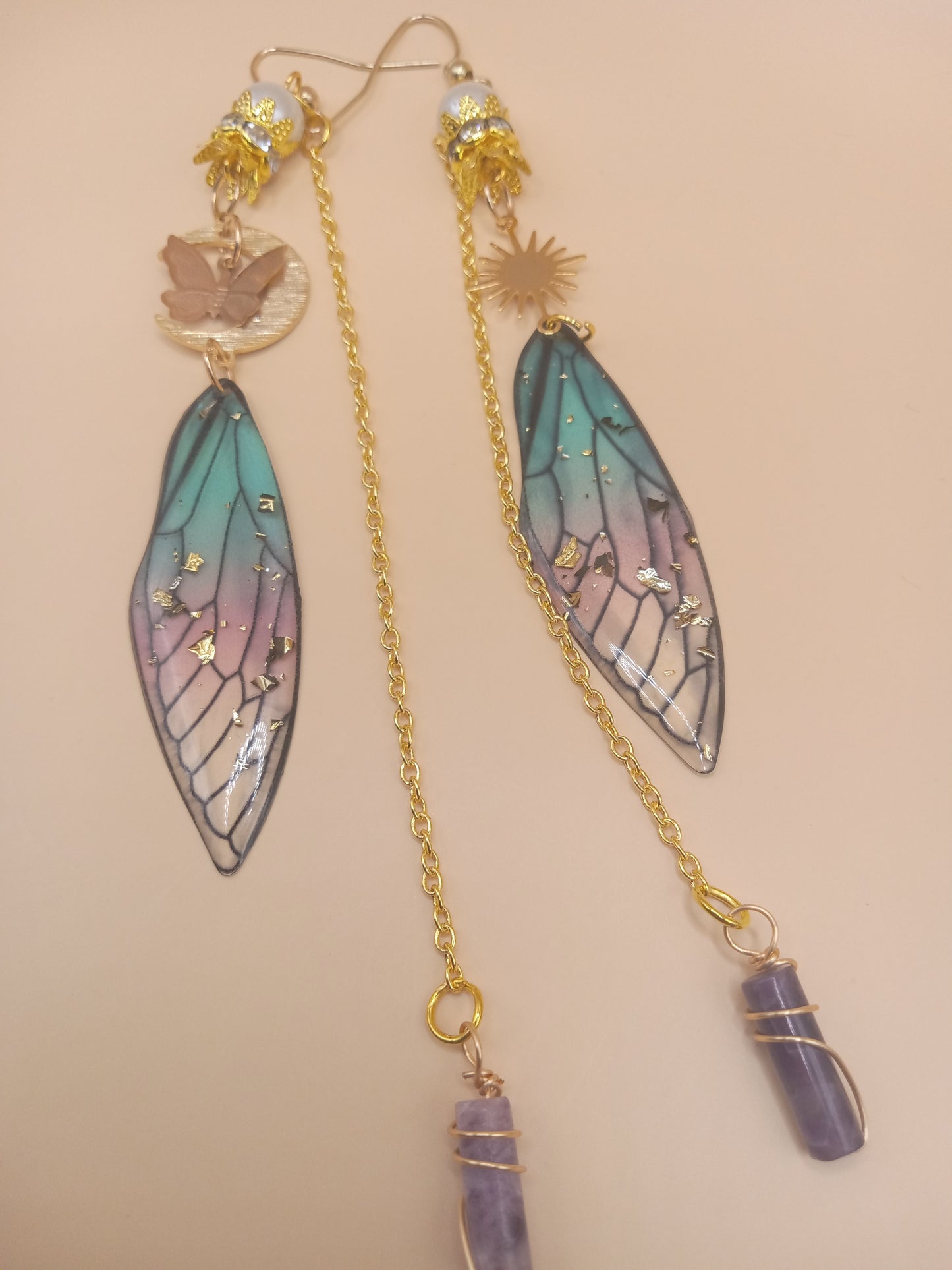 Sacred Moon Candle Co blue and violet fairy earrings with gold chains wing charms sun disc and amethyst drops