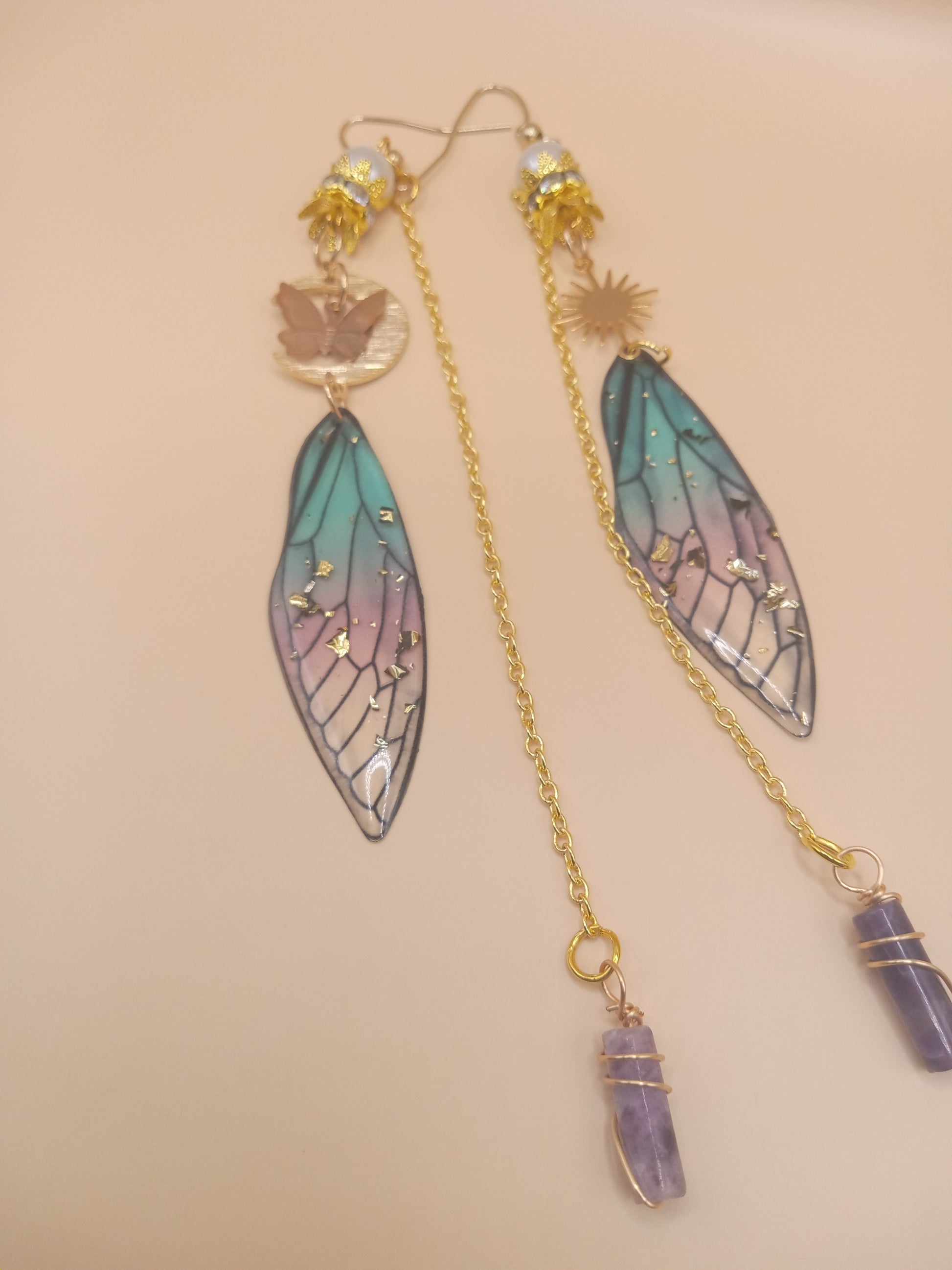 Sacred Moon Candle Co blue and violet fairy earrings with translucent wing pendants gold chains and amethyst points