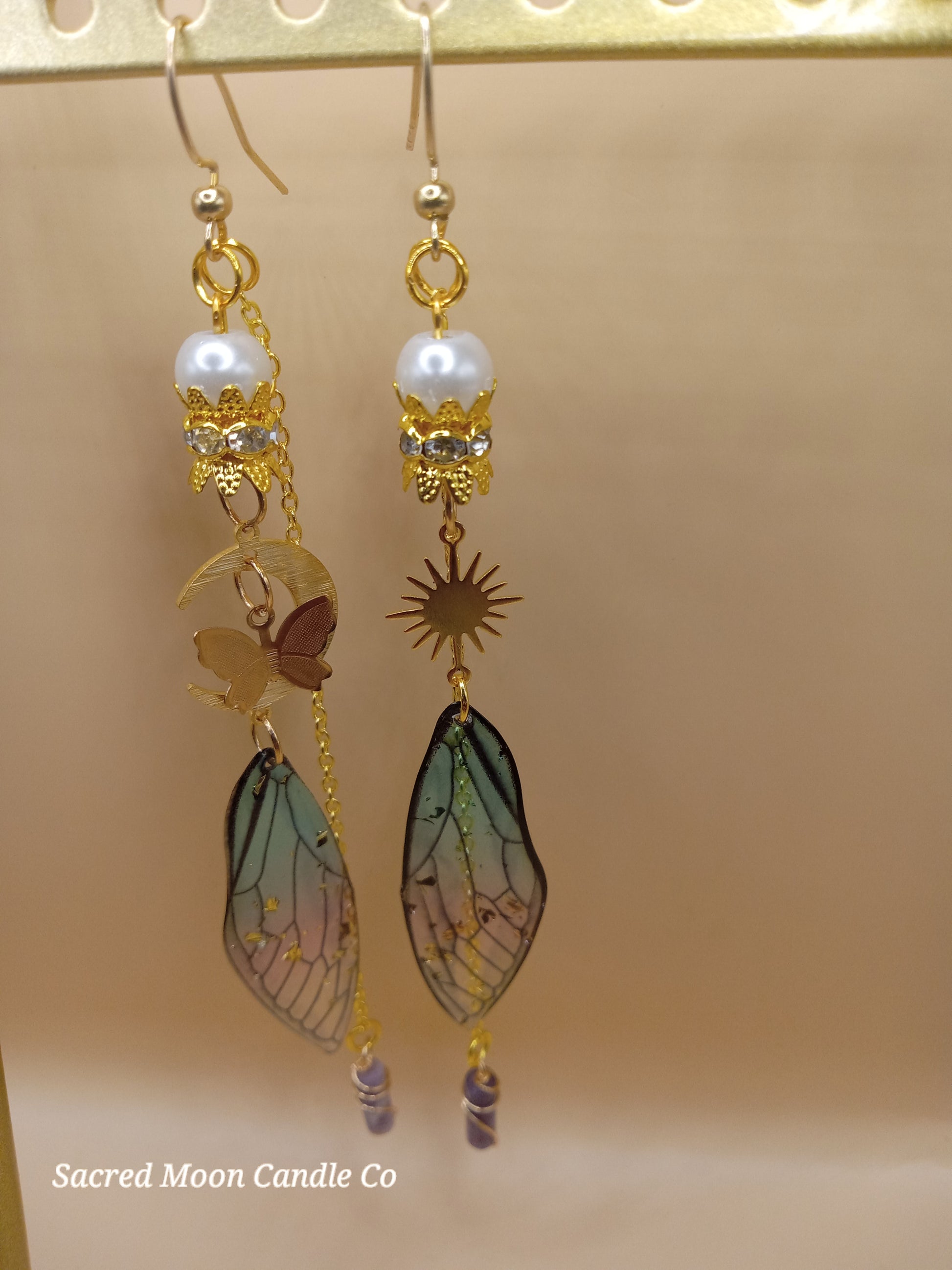 Sacred Moon Candle Co blue and violet fairy earrings with gold sun charms pearl accents and delicate wing dangles