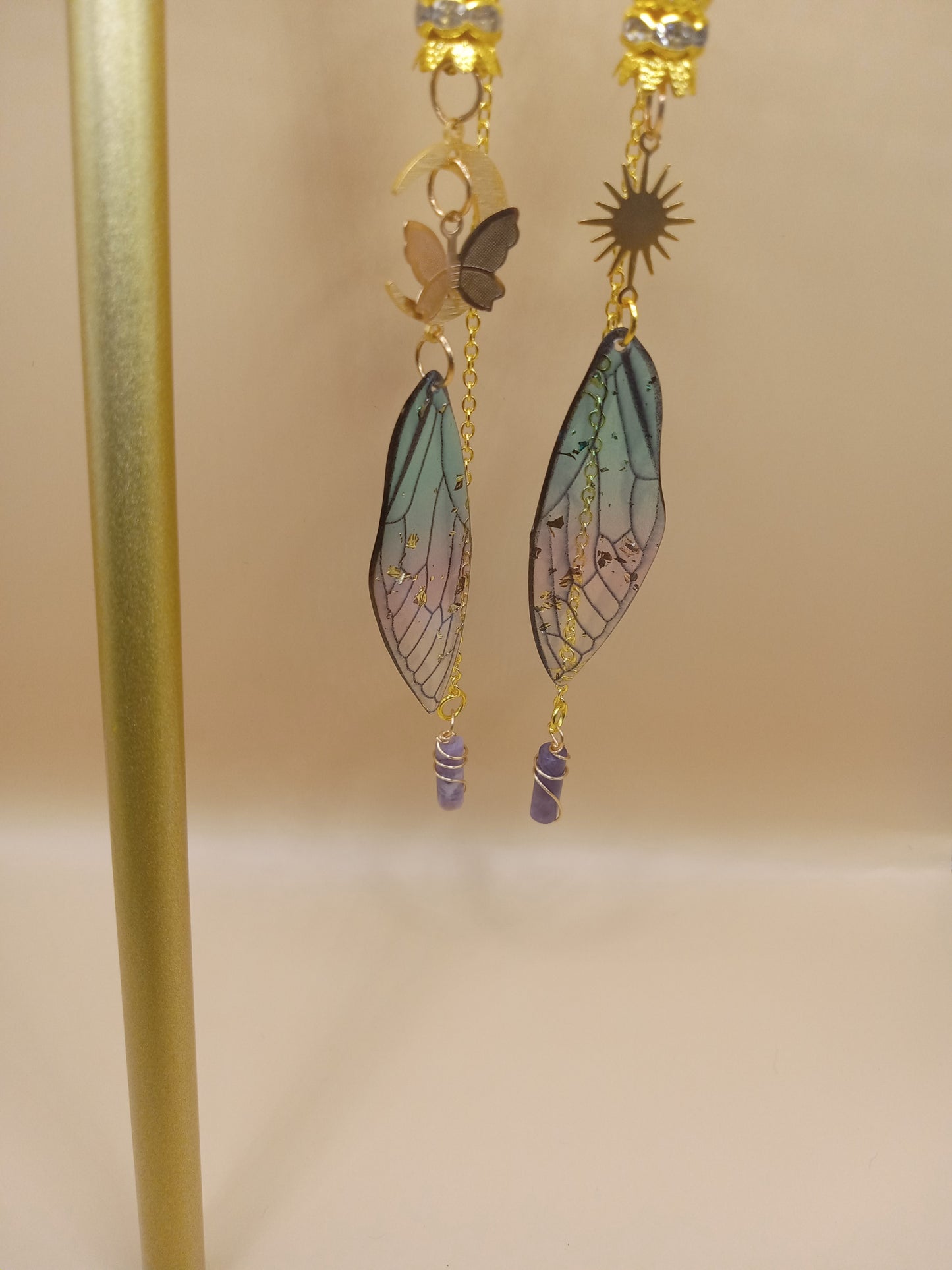 Sacred Moon Candle Co blue and violet fairy earrings with gold sun charm butterfly wing and dangling purple crystal beads