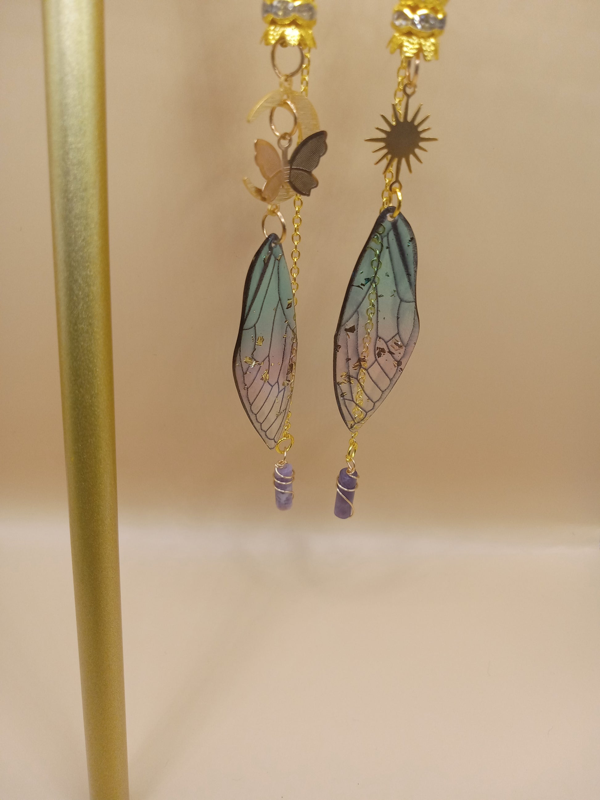 Sacred Moon Candle Co blue and violet fairy earrings with gold sun charm butterfly wing and dangling purple crystal beads