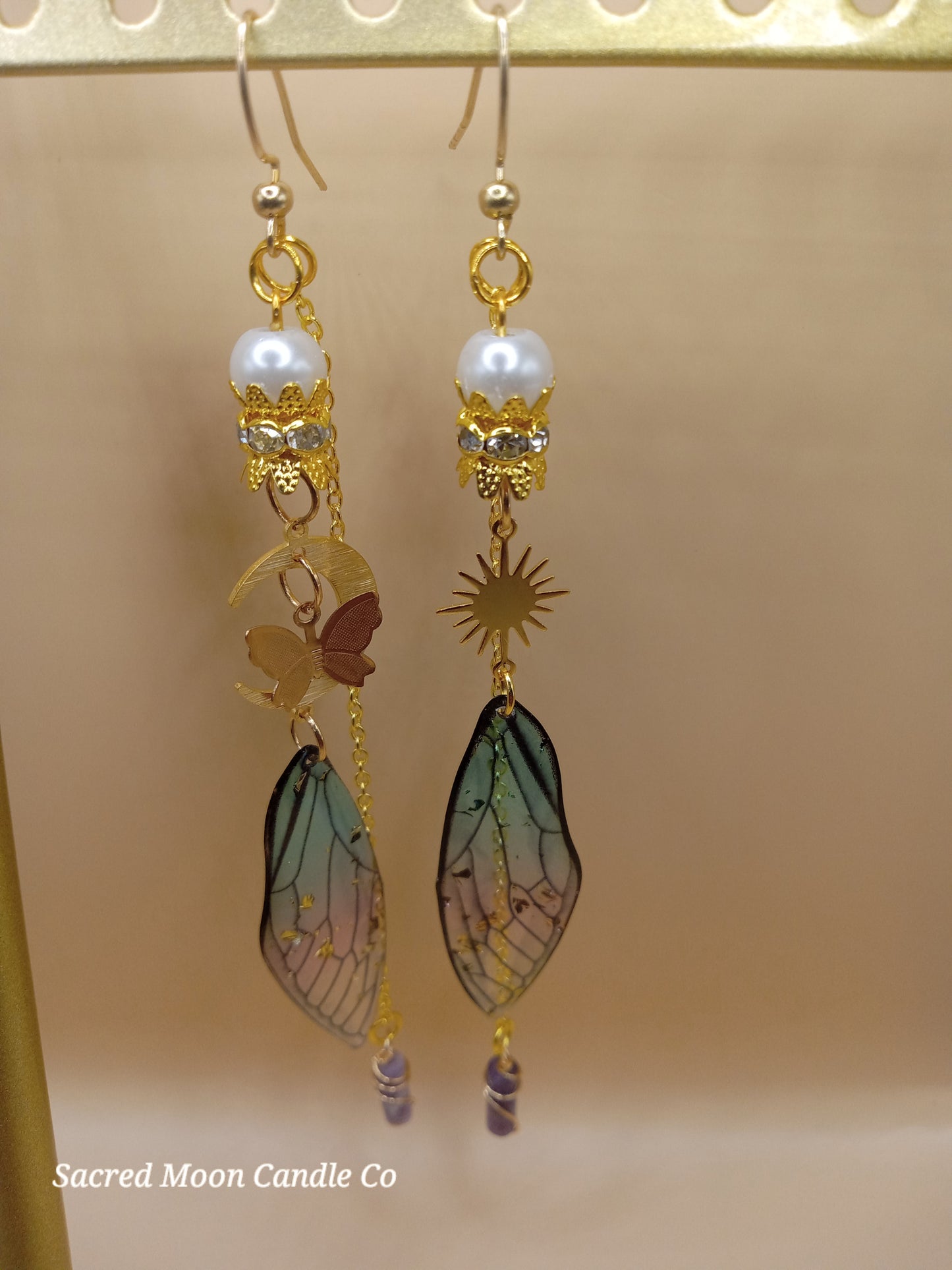 Sacred Moon Candle Co blue and violet fairy earrings with gold filigree pearls sun and wing charms