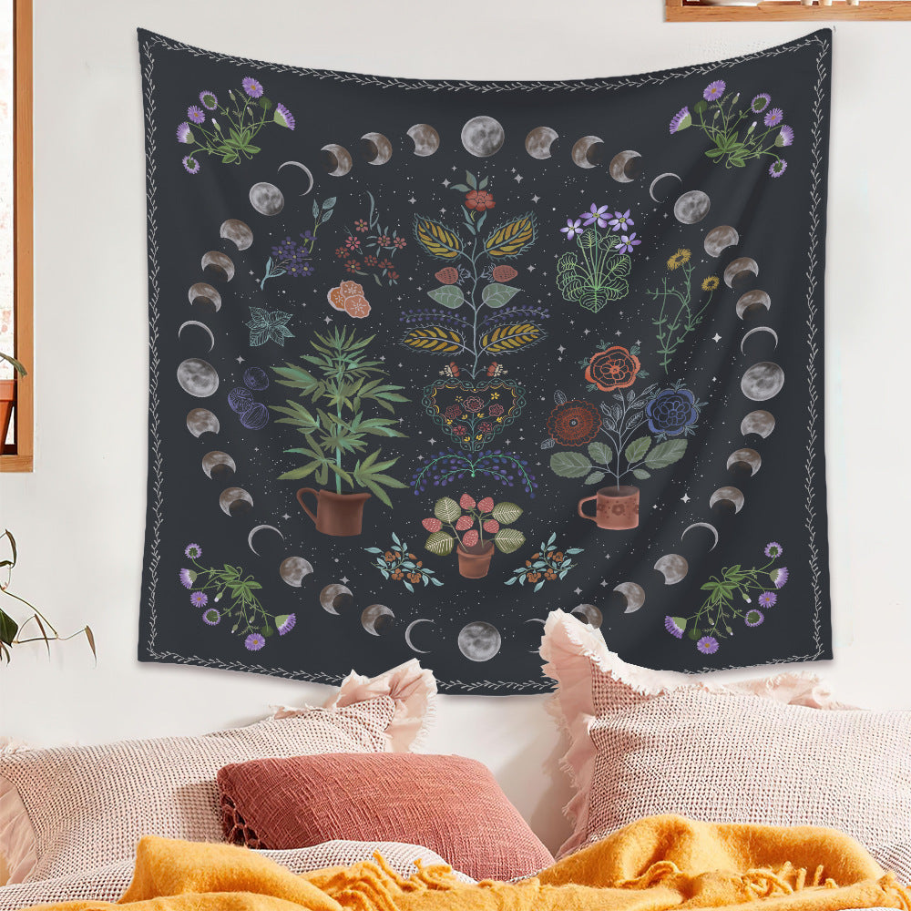 Sacred Moon Candle Co moon phase tapestry with floral and celestial design hanging above cozy bed