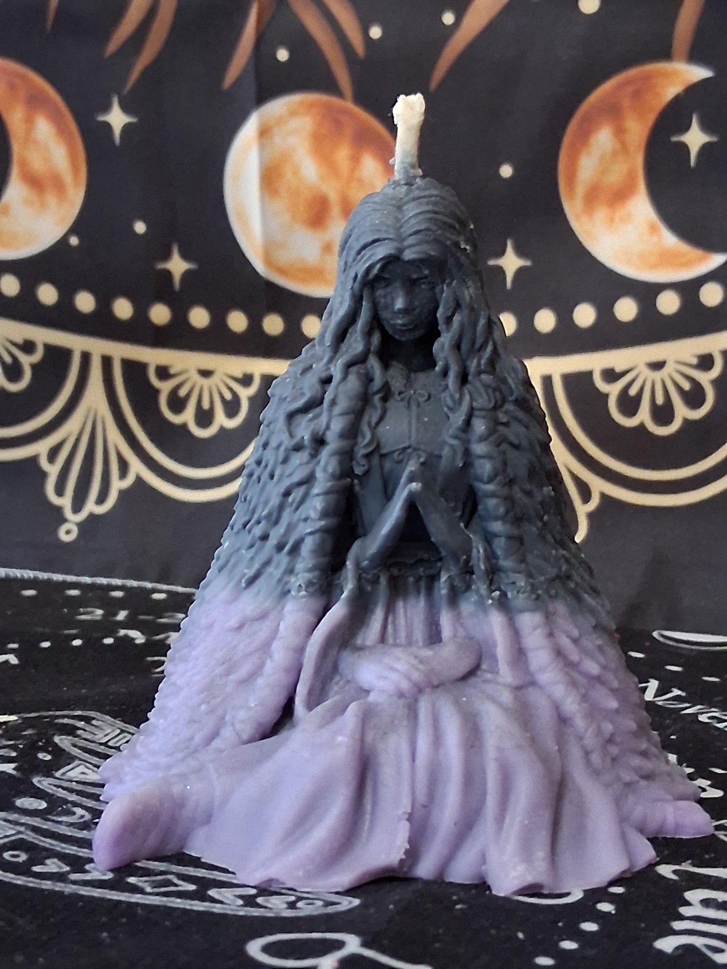 Sacred Moon Candle Co moon water bloom goddess ritual candle in purple and black, shaped like a praying goddess figure