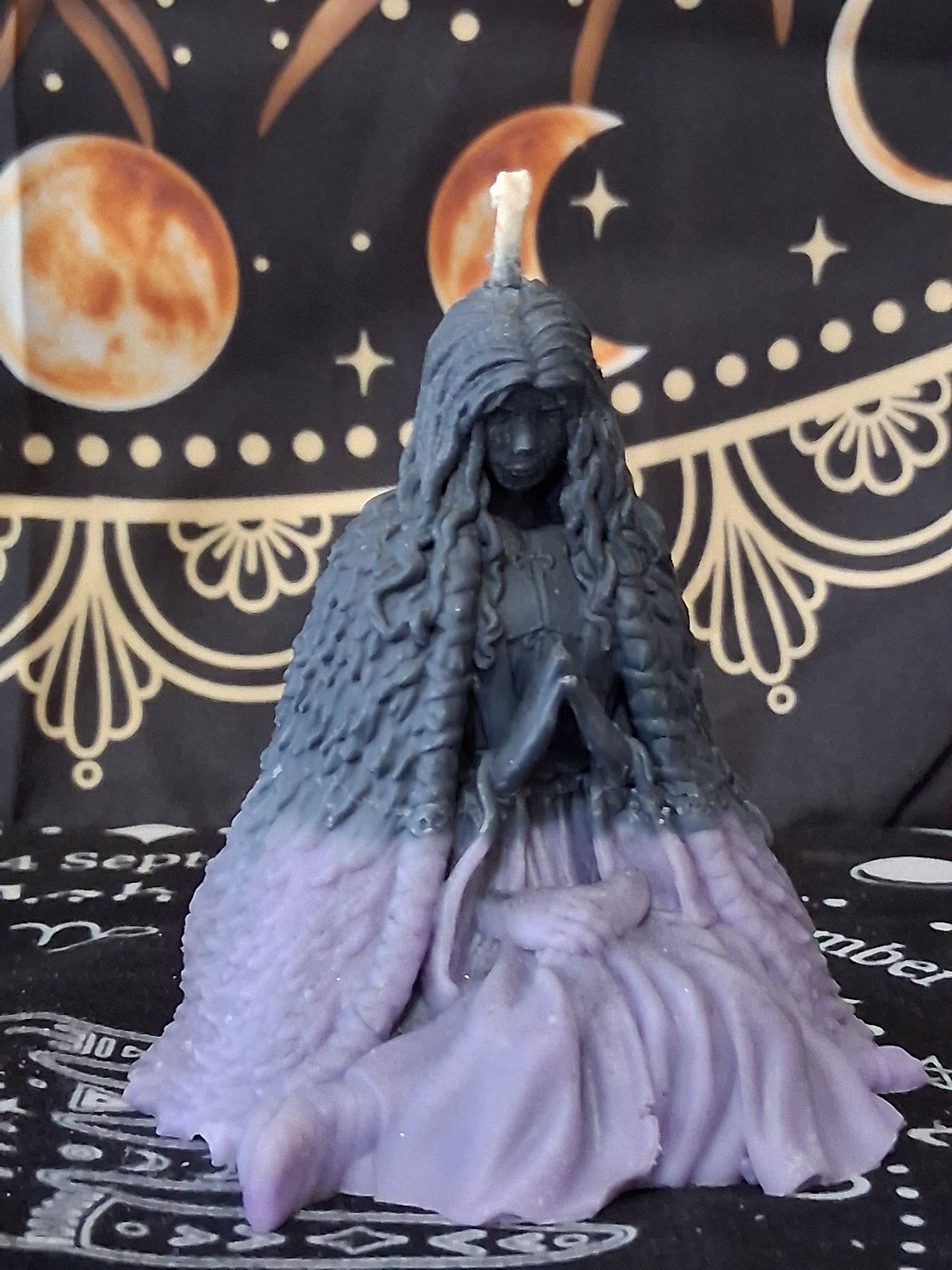 Sacred Moon Candle Co moon water bloom goddess ritual candle shaped like a seated woman in black and purple wax