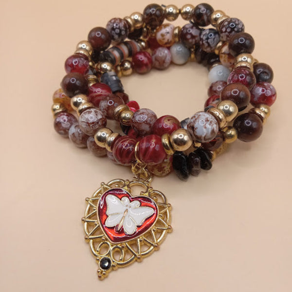 Sacred Moon Candle Co moth and flame bracelet stack with red and brown beads and gold heart charm