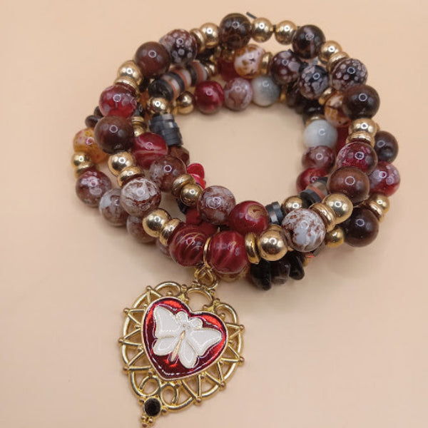 Sacred Moon Candle Co moth and flame bracelet stack with red and gold beads and heart charm with butterfly design