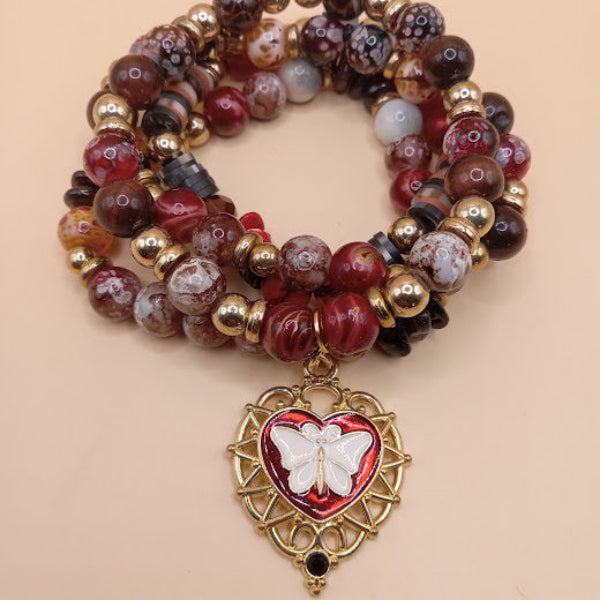 Moth and flame bracelet stack with red and brown beads and a gold heart charm by Sacred Moon Candle Co