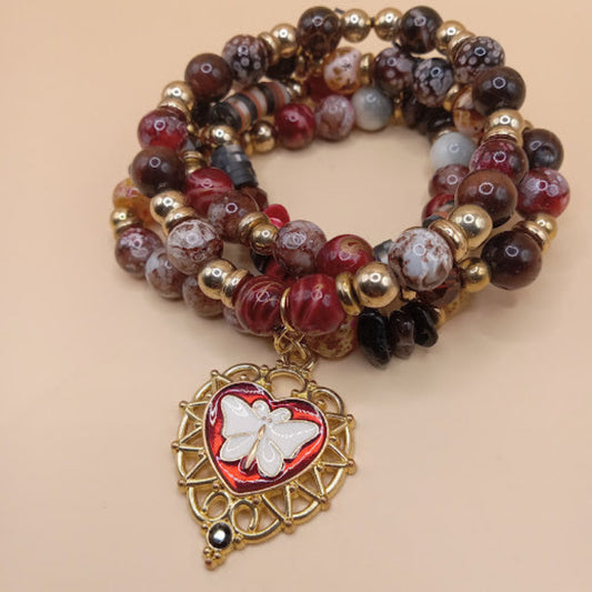 Sacred Moon Candle Co moth and flame bracelet stack with red and brown beads and butterfly heart charm