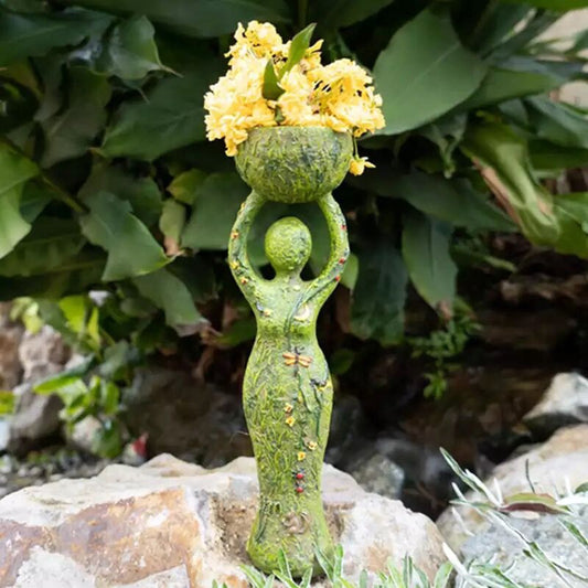 Green goddess altar statue holding a mossy bowl of yellow flowers textured vine details