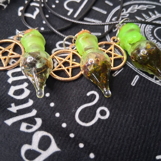 Sacred Moon Candle Co prosperity spell bottle necklace with green cork and pentacle charm on black cloth