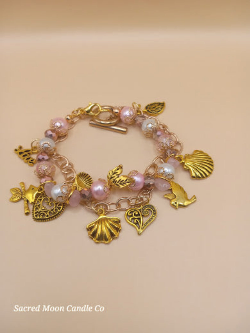 Aphrodite bracelet set by Sacred Moon Candle Co featuring gold charms and pink pearls bracelet stack