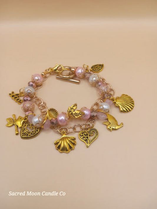 Aphrodite bracelet set by Sacred Moon Candle Co featuring gold charms and pink pearls bracelet stack