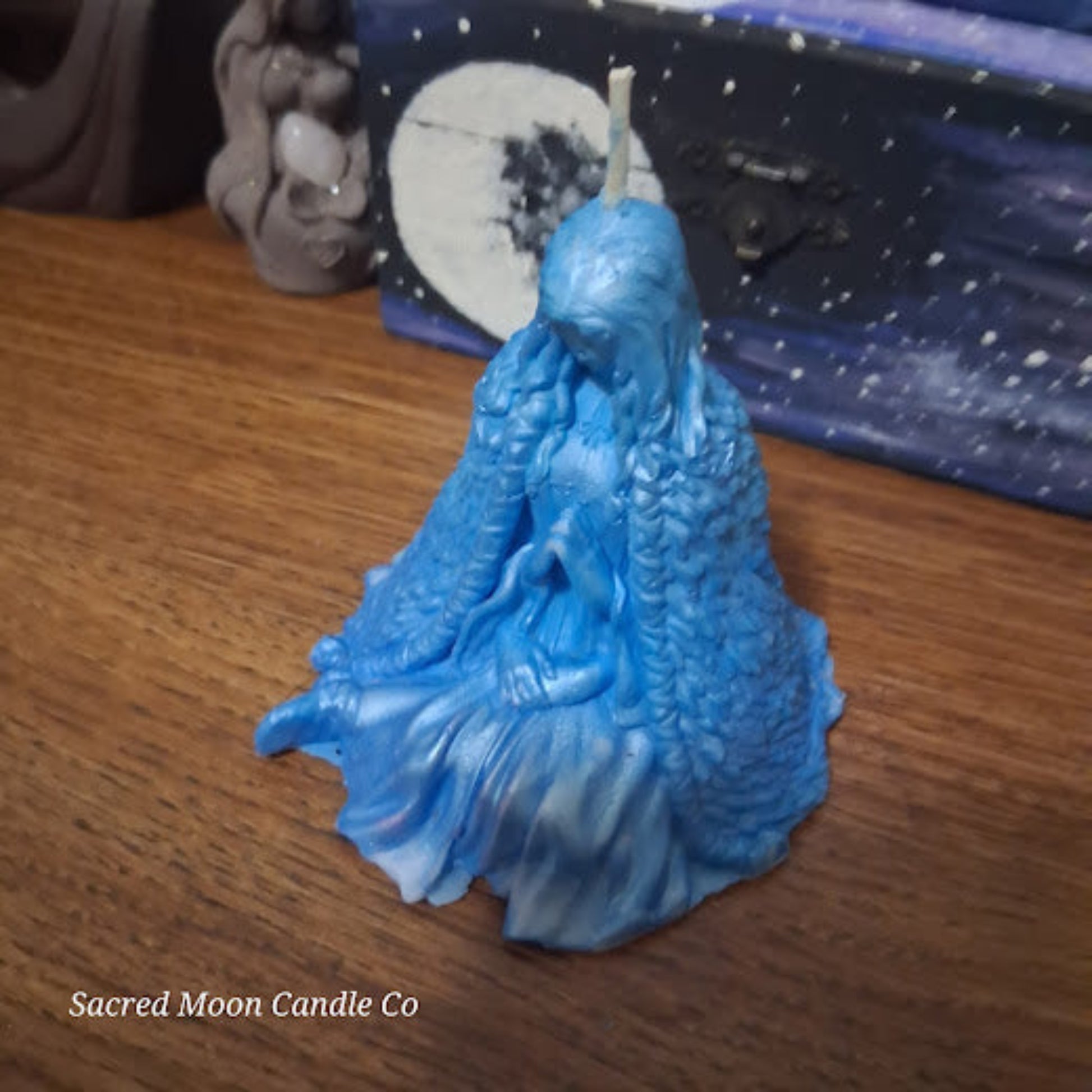 Blue Whispering Water Lily Goddess Candle 3.3oz sculpted seated goddess wax candle on wood table