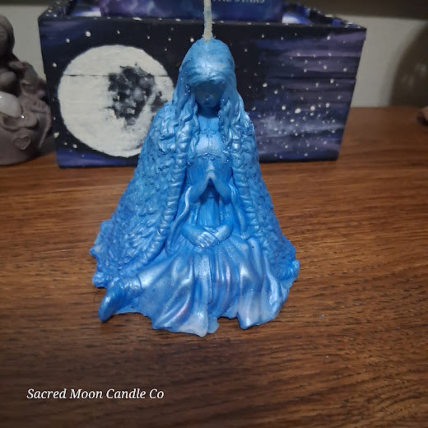 Sacred Moon Candle Co blue goddess candle seated on wood table Blue Whispering Water Lily Goddess Candle 3.3oz .