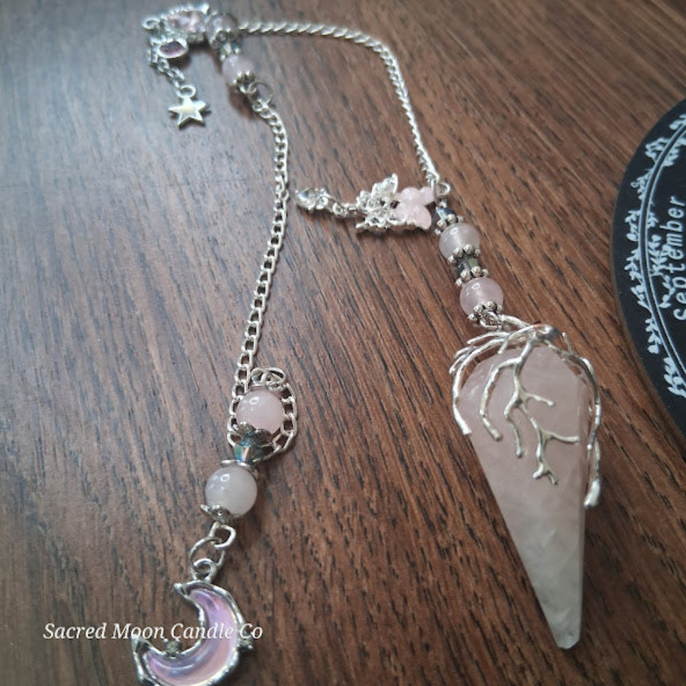 Sacred Moon Candle Co Seraphina's Heart Rose Quartz pendulum with silver chain and crystal beads on wood surface