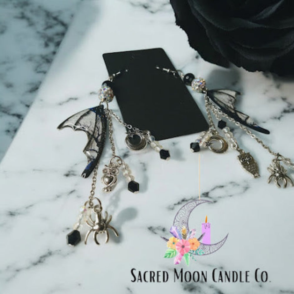 Sacred Moon Candle Co witches road batwing earrings with silver chains and black gemstone accents