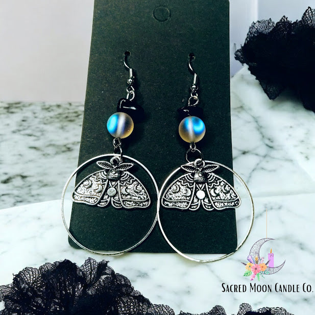 Sacred Moon Candle Co celestial moth dangle earrings with intricate moth design and blue bead accents