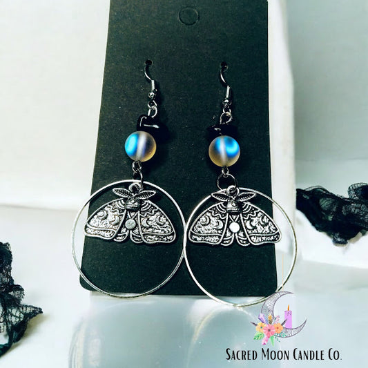 Sacred Moon Candle Co celestial moth dangle earrings with intricate silver design and blue bead accents