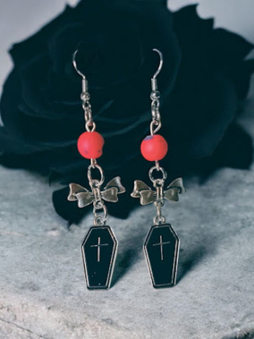 Sacred Moon Candle Co coffin and bow dangle earrings with black coffin charms, silver bows, and red beads