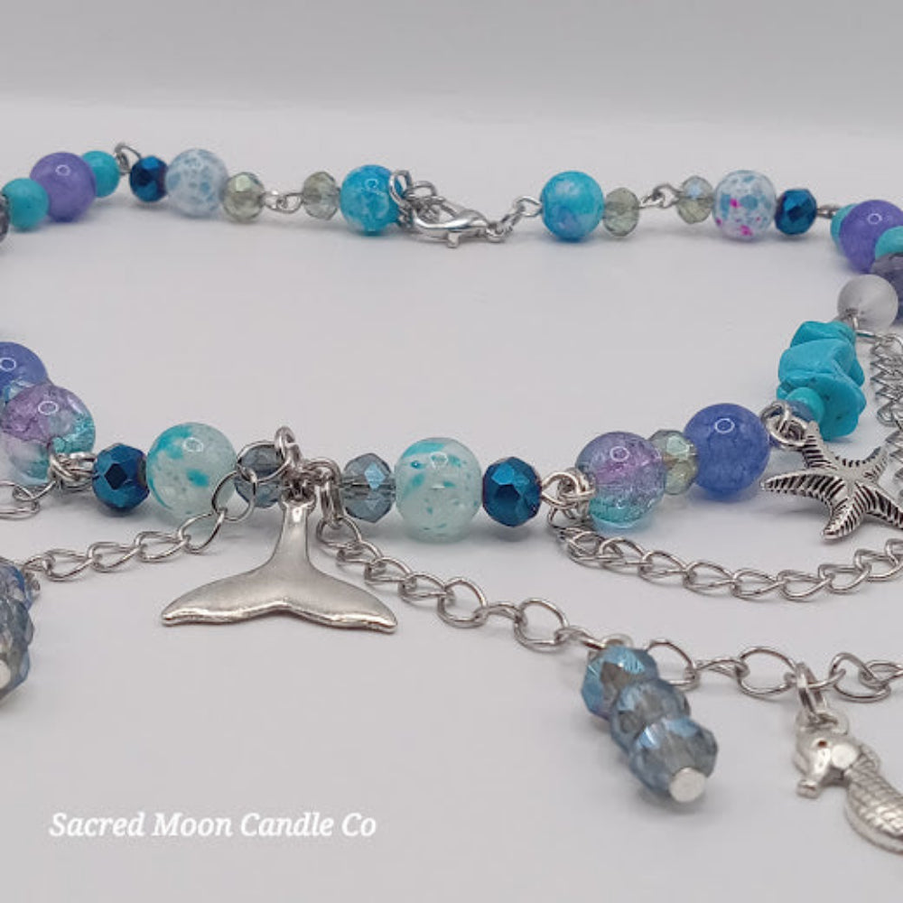 Sacred Moon Candle Co mermaid tail choker necklace with blue and purple beads and silver charms