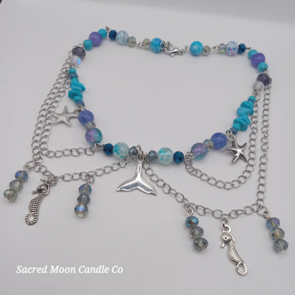 Mermaid tail choker necklace with blue beads, silver starfish, seahorse charms, and layered silver chains