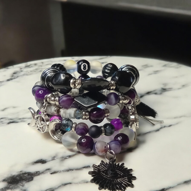 Sacred Moon Candle Co spiritual protection beaded bracelets stack featuring purple, black, and silver beads with charms
