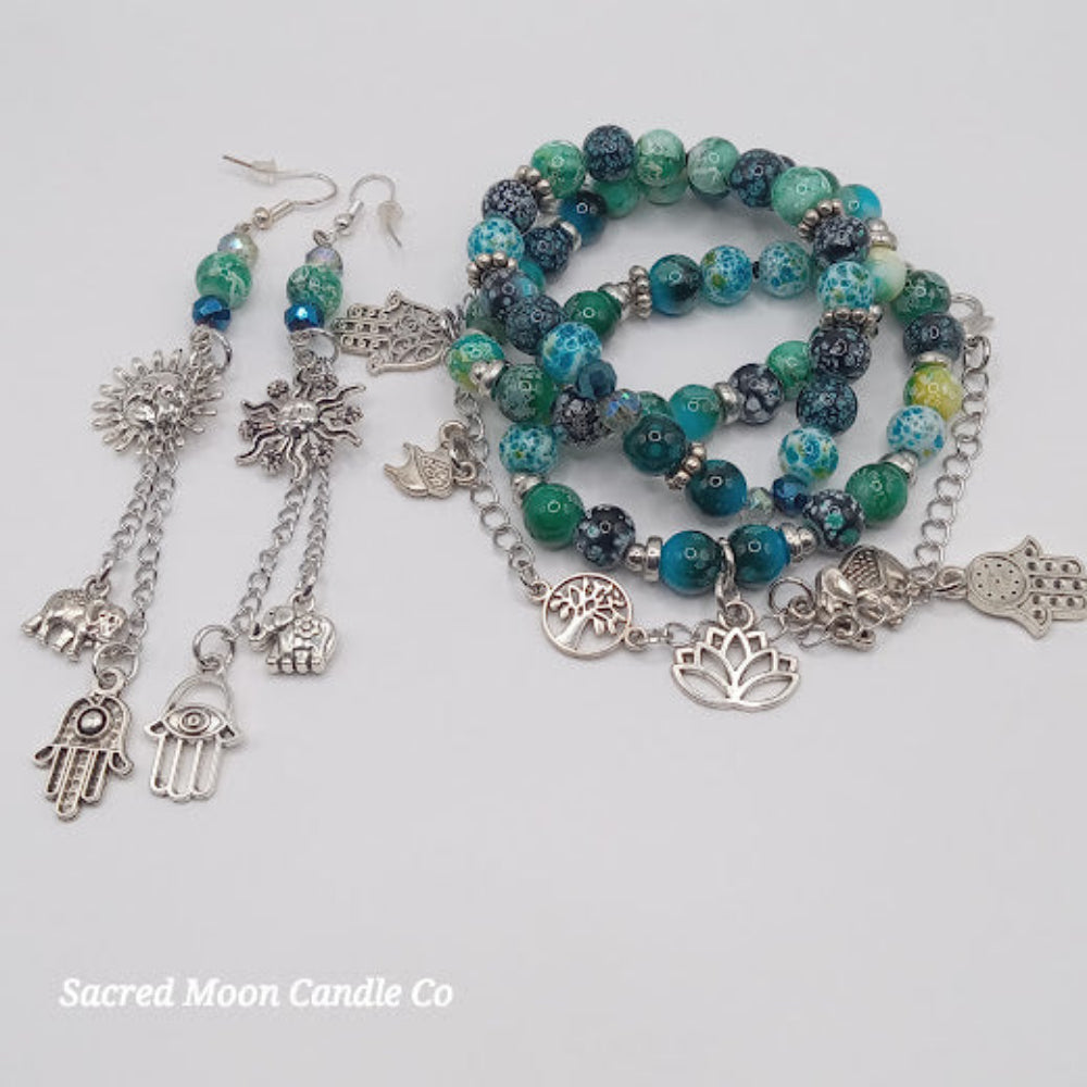 Teal boho earrings and bracelet stack with silver charms featuring elephants and lotus from Sacred Moon Candle Co