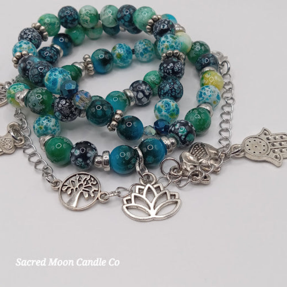 Sacred Moon Candle Co teal boho earrings and bracelet stack with silver charms and multicolored beads