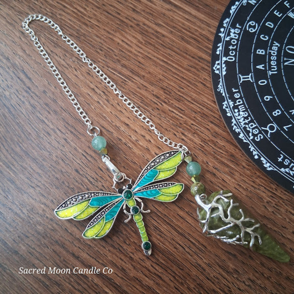 Unakite amazonite dragonfly pendulum with silver chain and detailed dragonfly wings on wooden surface