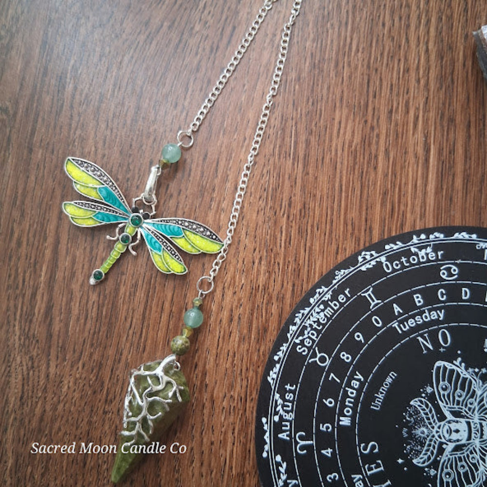 Sacred Moon Candle Co altar tools featuring unakite amazonite dragonfly pendulum on wooden surface