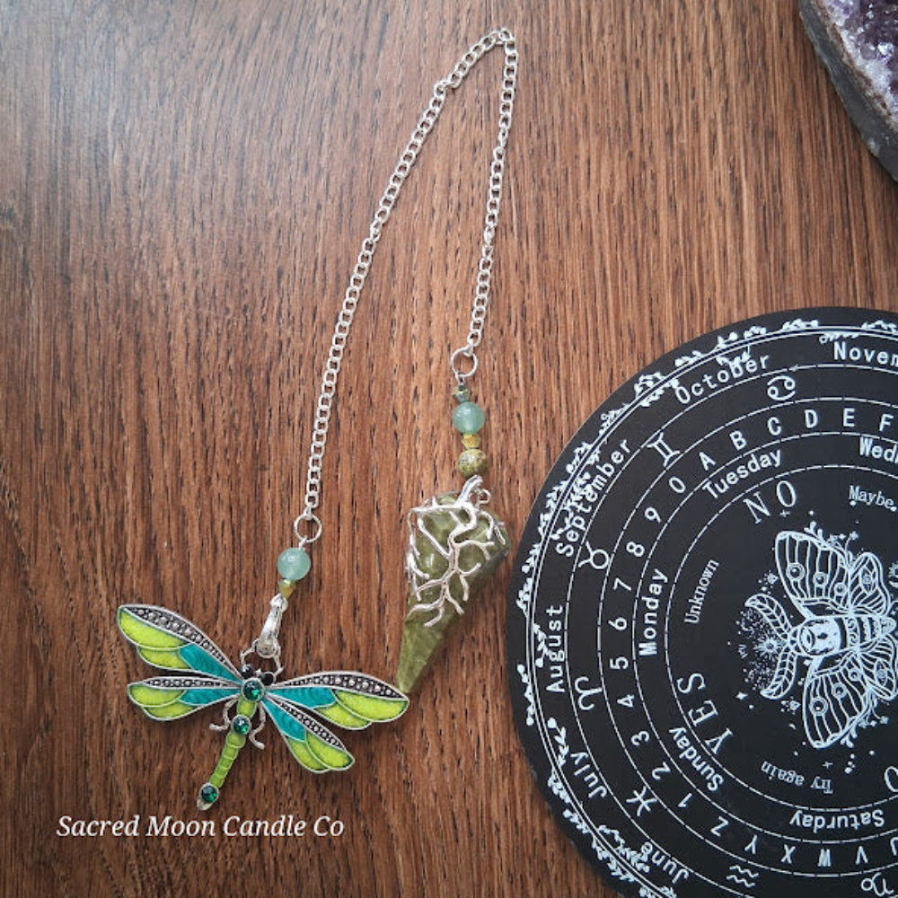 Unakite amazonite dragonfly pendulum with green stone and silver chain on wooden surface by Sacred Moon Candle Co