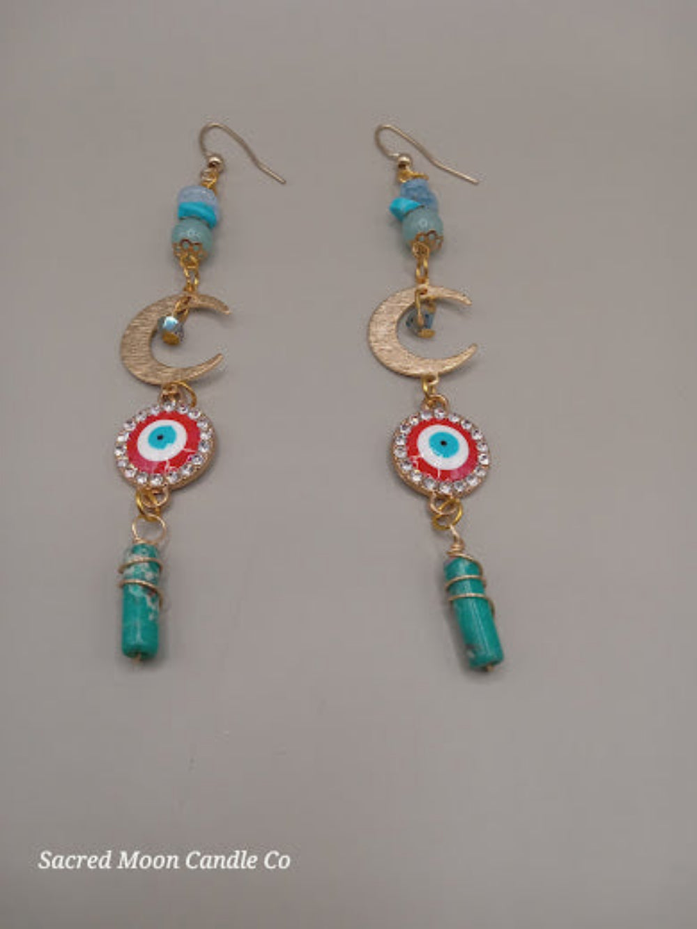 Sacred Moon Candle Co wire wrapped evil eye earrings featuring gold crescent moons and turquoise beads