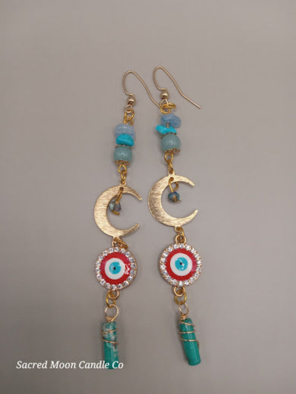 Sacred Moon Candle Co wire wrapped evil eye earrings with gold crescent moons and blue stone accents
