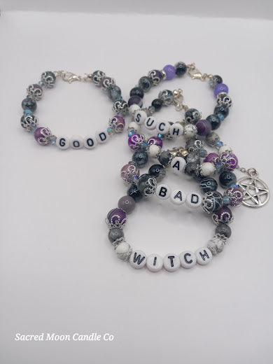 Sacred Moon Candle Co witch bracelet stack featuring beaded designs with letter beads spelling good such a bad witch