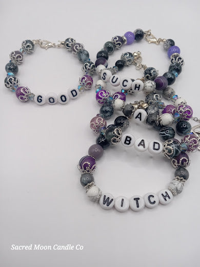 Witch bracelet stack by Sacred Moon Candle Co featuring beaded bracelets with white letter beads spelling good such a bad witch