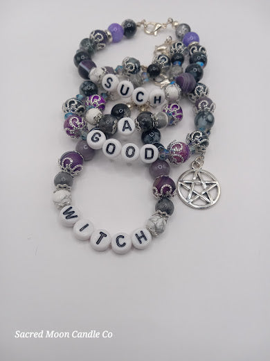 Witch bracelet stack by Sacred Moon Candle Co with purple black beads and a pentagram charm