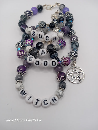 Witch bracelet stack by Sacred Moon Candle Co featuring purple and black beads with a pentacle charm
