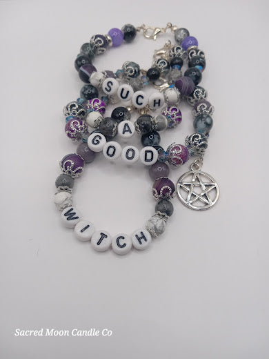 Sacred Moon Candle Co witch bracelet stack with purple, black, and gray beads and pentagram charm