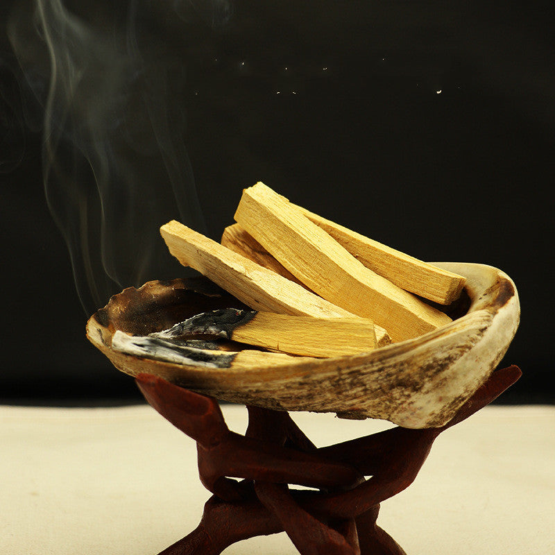 Sacred Moon Candle Co palo santo for meditation and rituals sticks in burning shell with smoke on wooden stand