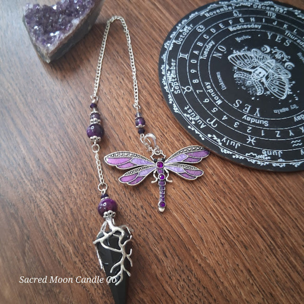 Black tourmaline Purple Tigers Eye Dragonfly Pendulum with silver chain and purple accents on wooden surface