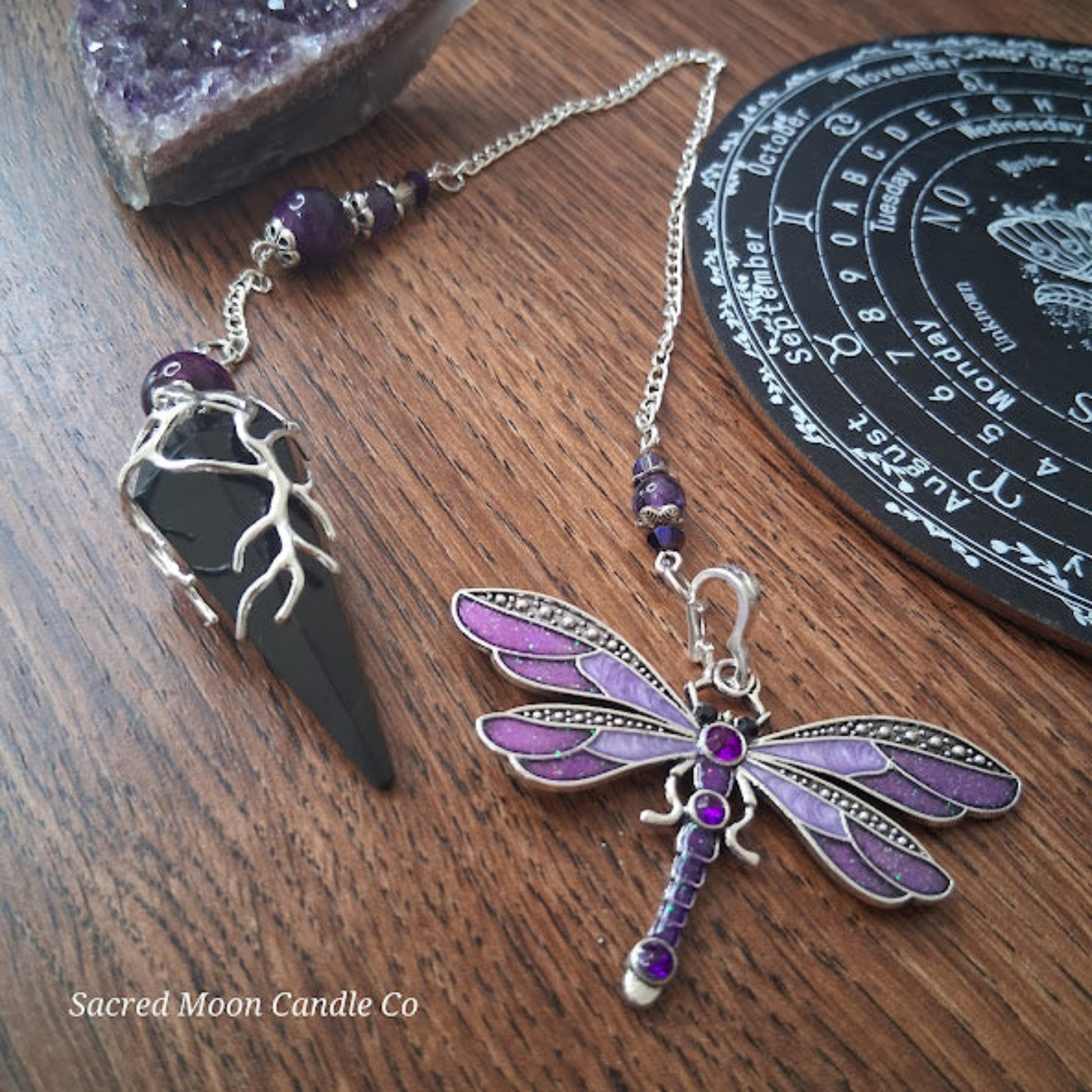 Black tourmaline Purple Tigers Eye Dragonfly Pendulum altar tool by Sacred Moon Candle Co on wooden surface