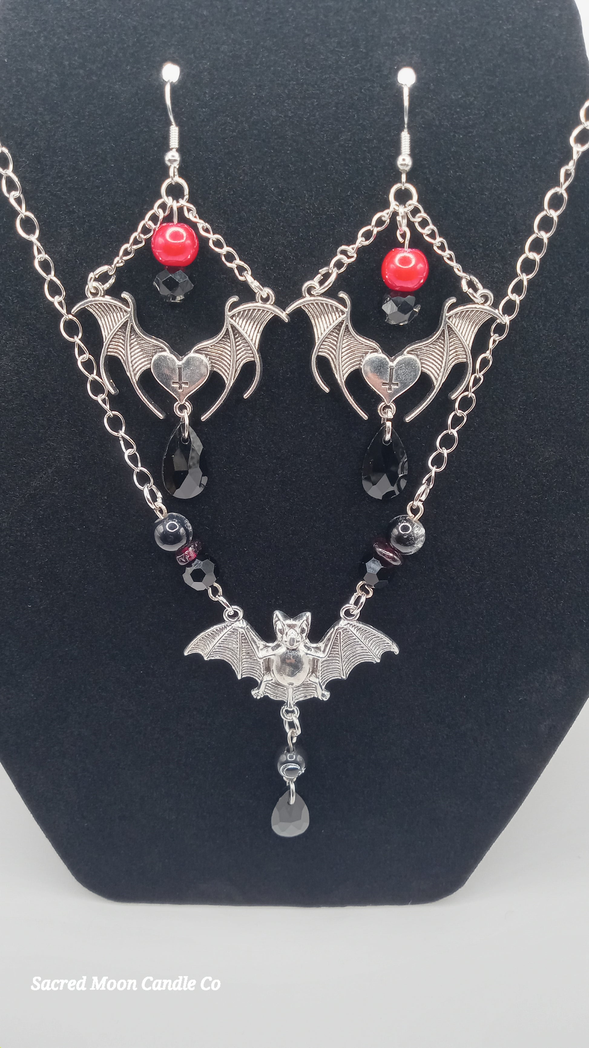 Sacred Moon Candle Co gothic bat jewelry set with silver bat earrings and matching necklace with red and black beads
