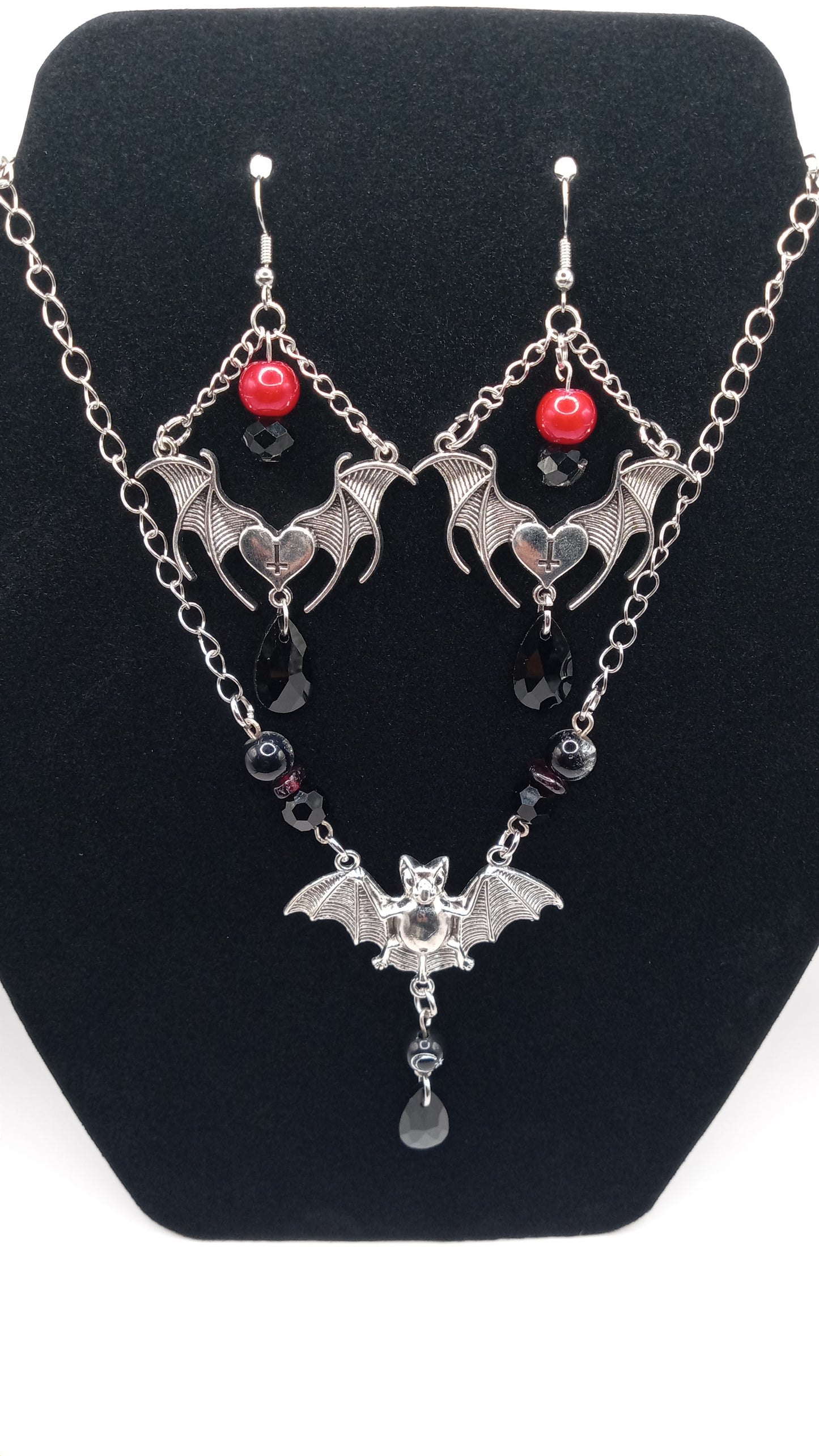 Sacred Moon Candle Co gothic bat jewelry set featuring silver bat earrings and matching necklace with red and black bead accents