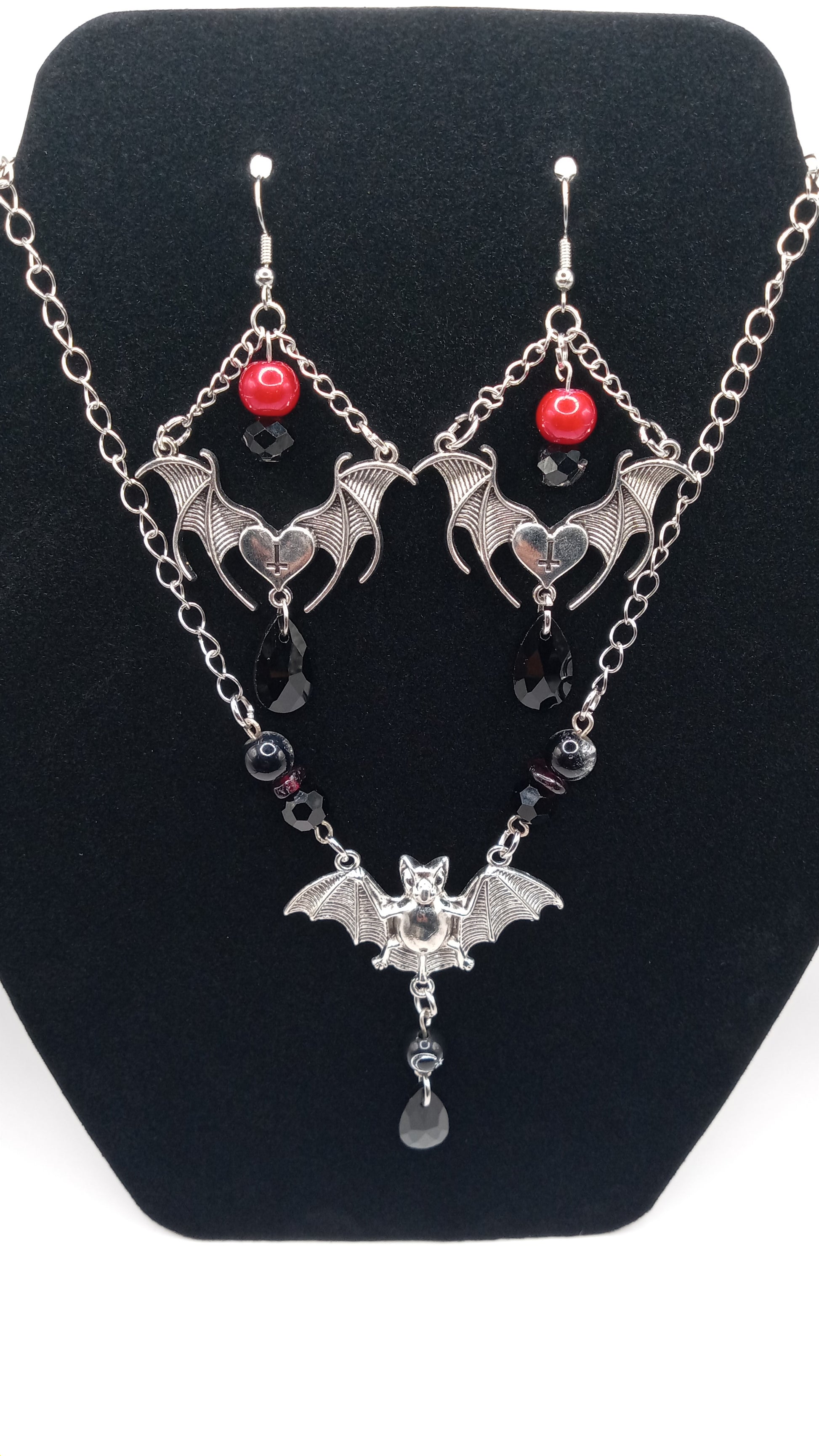 Sacred Moon Candle Co gothic bat jewelry set featuring silver bat earrings and matching necklace with red and black bead accents