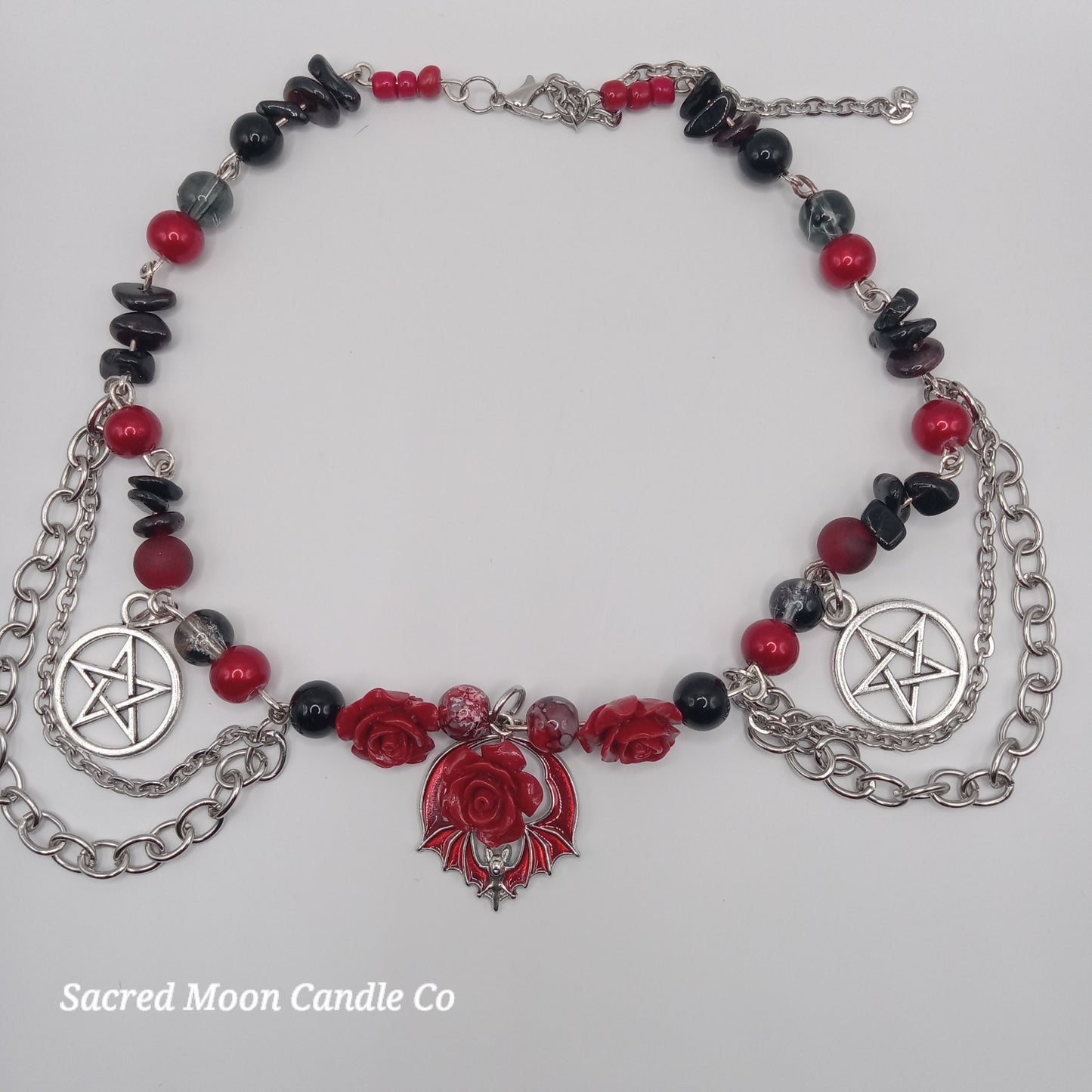 Handmade rose bat choker necklace with red roses, black and red beads, silver pentagram charms, and chain details