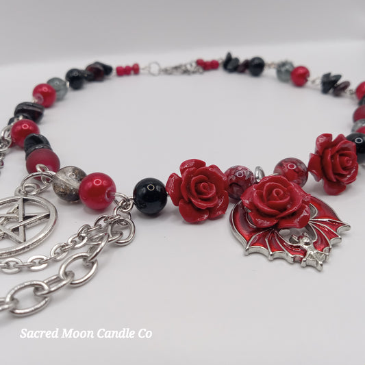 Handmade rose bat choker necklace with red rose beads, black and red accents, and silver chain from Sacred Moon Candle Co