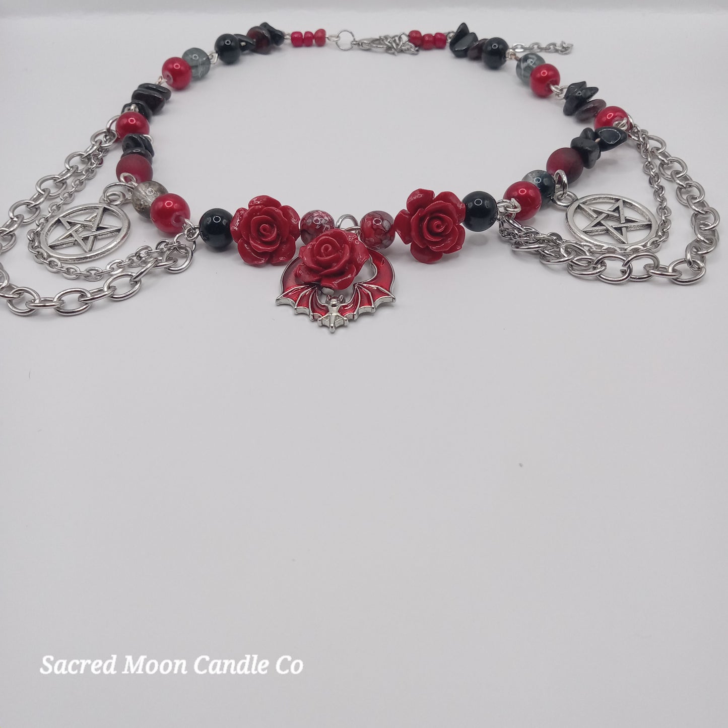 Handmade rose bat choker necklace with red roses, bat charm, pentagram charms, and silver chains by Sacred Moon Candle Co