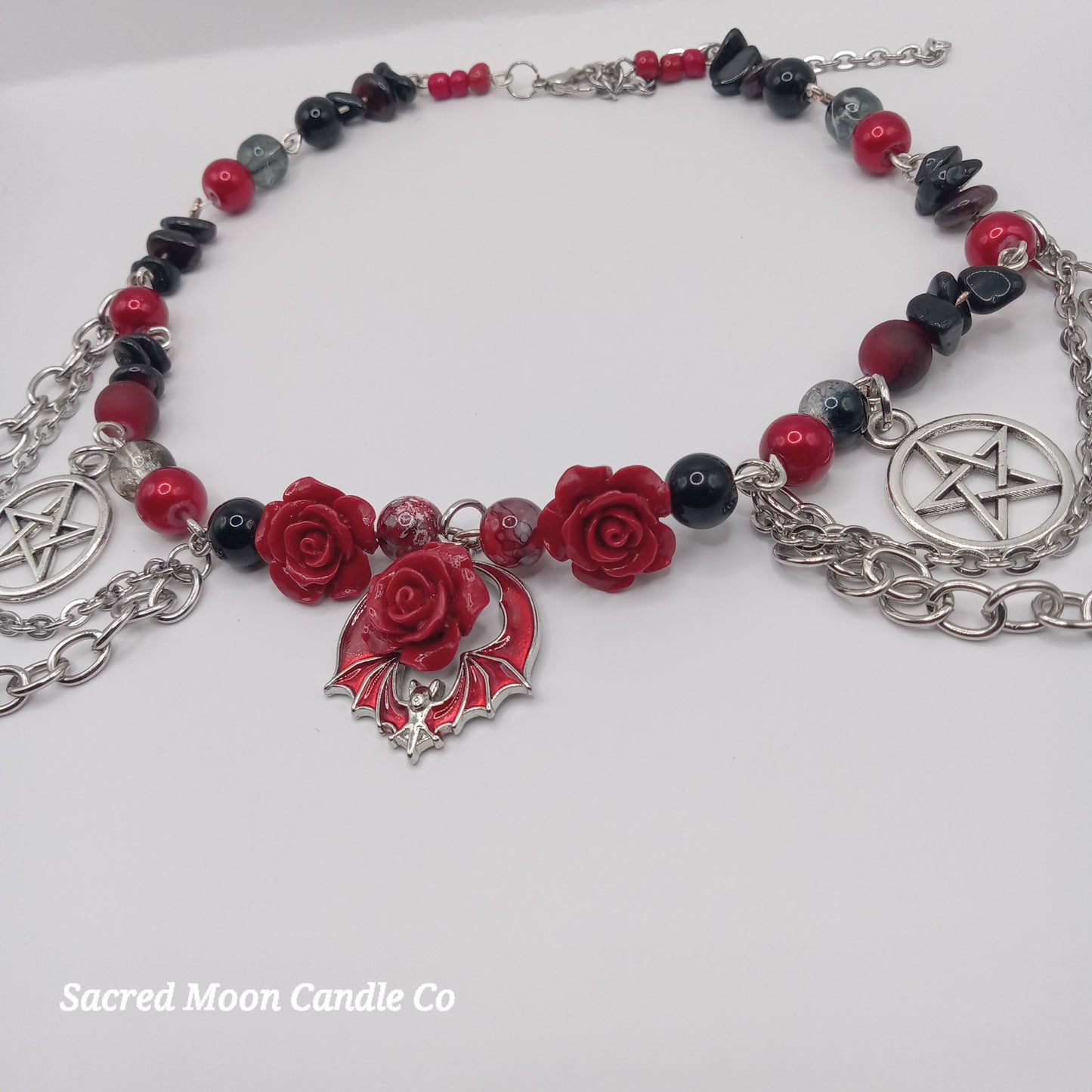 Handmade rose bat choker with red roses, black beads, and silver pentagram charms by Sacred Moon Candle Co